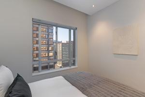 Un dormitorio con una cama y una ventana grande. en Stay In Luxury at The Pullman, en Ciudad del Cabo