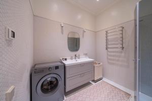 a bathroom with a washing machine and a sink at Charming flat with beautiful riverside views in Rīga