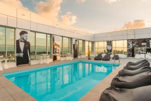 a large swimming pool with a large building with windows at HF Ipanema Park in Porto
