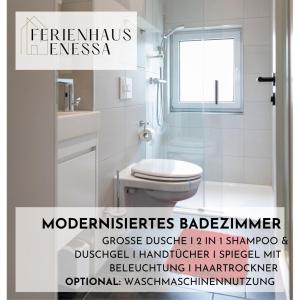 a white bathroom with a toilet and a window at Ferienhaus Enessa in Lauchhammer