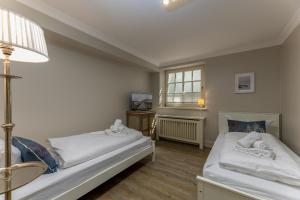 a room with two beds and a lamp and a window at Appartement Salzwiese in Tinnum