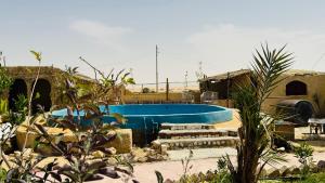 a blue swimming pool with steps next to a house at ادرار احكيك in Siwa