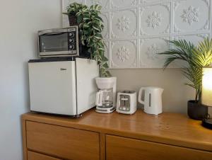a microwave on top of a refrigerator on a wooden cabinet at Studio 10 - 2 min du Bord de l'eau Foyer & Barbecue in Sainte-Anne-de-Beaupré