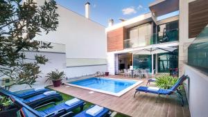 a house with a swimming pool and two blue chairs at Lua - Private Pool - 8 Guests - Albufeira in Albufeira