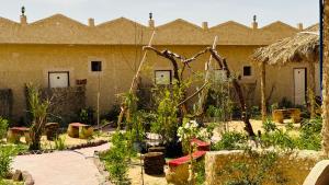 a garden in front of a building with plants at ادرار احكيك in Siwa