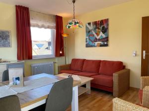 a living room with a red couch and a table at Altstadtwohnung 2, Süderstraße in Wyk auf Föhr