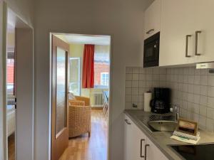 a kitchen with a sink and a counter top at Altstadtwohnung 2, Süderstraße in Wyk auf Föhr