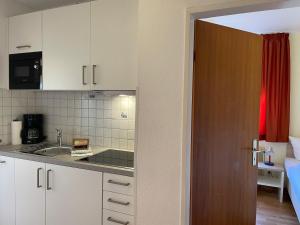 a kitchen with white cabinets and a sink at Altstadtwohnung 2, Süderstraße in Wyk auf Föhr +14 photos