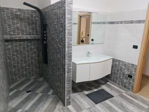 un bagno con lavandino e specchio di Casa Vacanza Martano a Martano Altre 6 foto