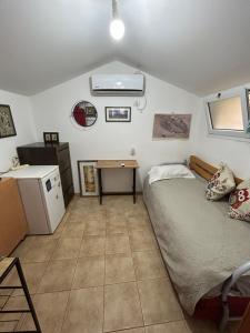 a small bedroom with a bed and a desk at Panorama Kinneret נוף כנרת, צפת in Safed