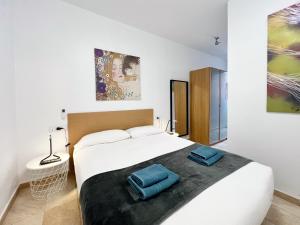 a bedroom with a bed with two blue bags on it at Torre de Gracia Barcelona in Barcelona