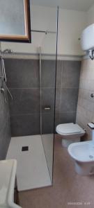 Un baño con ducha de cristal y un inodoro. en Villa Frailis, en Àrbatax