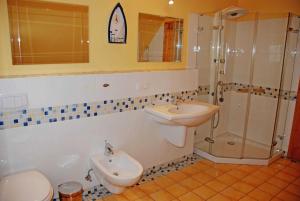 a bathroom with a sink and a toilet and a shower at Ferienappartements zum Ostseestrand mit Terrasse in Lobbe