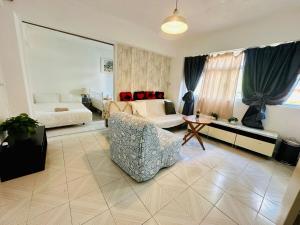 un soggiorno con un divano e una poltrona di Spacious House Near Soho & PmQ a Hong Kong