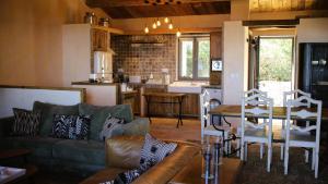 a living room with a couch and a table and a kitchen at Domaine de Gialla Bergerie Carta, 6 pers, montagne, vue mer in Porto-Vecchio