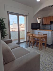 a living room with a couch and a table with chairs at Al Belvedere di San Nicola Arcella in San Nicola Arcella