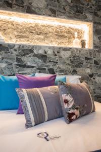 a bed with pillows on it with a stone wall at Y Palmela - Boutique Apartments in Palmela +66 photos
