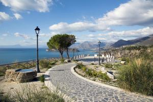 a walkway next to the water with two street lights at Al Belvedere di San Nicola Arcella in San Nicola Arcella