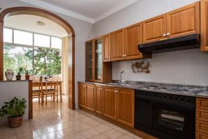 una cocina con armarios de madera y estufa negra en Gardenia Home, en Palermo 14 fotos más