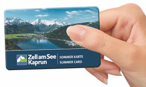 una mano con una tarjeta de visita con un lago y montañas en Haus Vera, en Zell am See