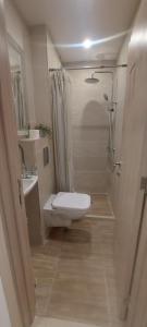a small bathroom with a toilet and a shower at Condo Santosha on the beach in Pomorie
