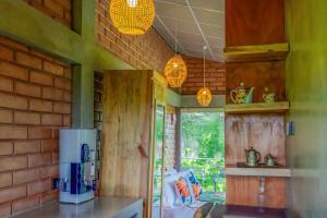 a kitchen with green walls and a kitchen with a microwave at Heliconia Ledge in Mawanella