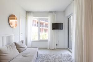 a white living room with a couch and a window at LECOMTE - The Shoreline Green 153 in Ostend