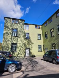 a large building with cars parked in front of it at Paulas room. in Riga