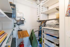 a walk in closet with white cabinets and shelves at LECOMTE - The Shoreline Green 153 in Ostend