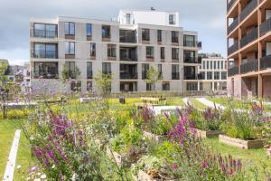 a garden in front of a building with purple flowers at LECOMTE - The Shoreline Green 153 in Ostend