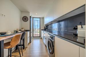 cocina con encimera, lavadora y secadora en Vista Castillo, en Denia