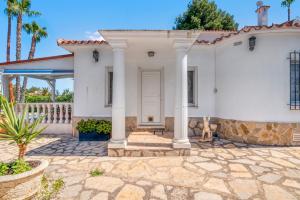 Una casa blanca con un gato sentado en el patio delantero. en Villa Sophie, en Denia