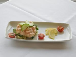a plate of food with shrimp and tomatoes and lime slices at Cullen Bay Hotel in Cullen +61 photos