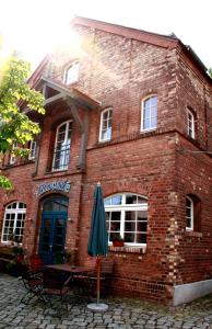 a brick building with an umbrella in front of it at Pension zur Postmeile in Bad Belzig