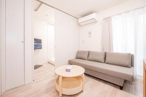 a living room with a couch and a table at 67 Apartment Ueno in Tokyo