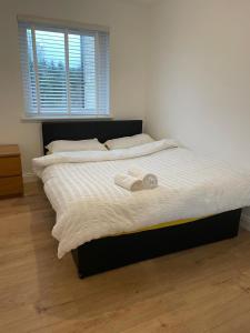 a bed with two towels on it in a bedroom at 2 Bed 2 Bath Flat 27Atholway in Uphall