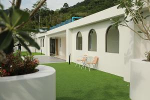 ein weißes Haus mit grünem Rasen in der Unterkunft Fantasea Kamala 1 BR Near Fantasea Show & Beach 505 in Phuket