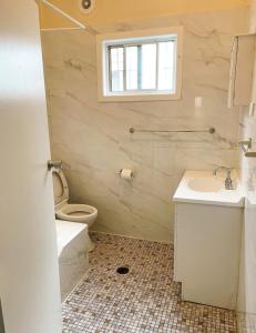 Un baño con lavabo, inodoro y ventana. en La Casa Di Dicembre, en Sídney