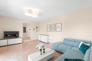 a living room with a blue couch and a tv at Vista OLIVO in Brtonigla