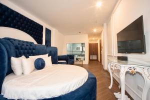 a bedroom with a large bed and a television at Royal Boutique Hotel in Ða Phúc