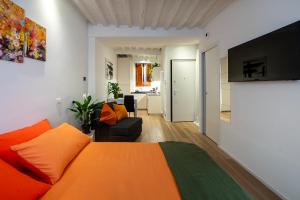a bedroom with an orange bed and a living room at La Nicchia Apartment- Centralissimo in Siena +32 photos