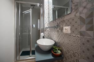 a bathroom with a sink and a shower at La Nicchia Apartment- Centralissimo in Siena