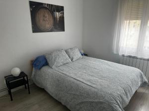 a bedroom with a bed and a clock on the wall at Tu hogar en Logroño in Logroño