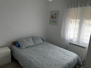 a small bedroom with a bed and a window at Tu hogar en Logroño in Logroño