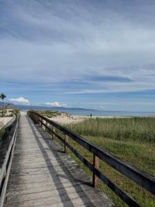 a wooden boardwalk leading to the beach at Camino Fisterra Beach - Apartment in Fisterra