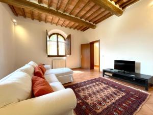 a living room with a white couch and a tv at Casa Peragna 2,8km from the Center in Siena