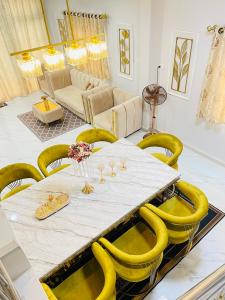 a dining room with a long table and yellow chairs at Tuan Homestay at Narathiwat in Narathiwat