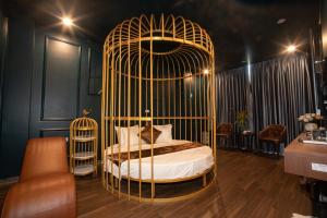 a gold cage with a bed in a room at Royal Boutique Hotel in Ða Phúc