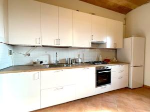 a kitchen with white cabinets and a refrigerator at Casa Peragna 2,8km from the Center in Siena +8 photos