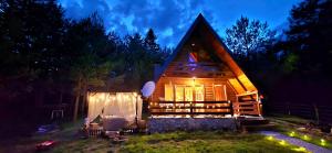 a log cabin with a lit up window at night at Chalet with outdoor jacuzzi near Sarajevo in Pale